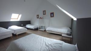 Juigné-sur-Loire杜穆尼耶旅舍的一间卧室设有三张床和窗户。