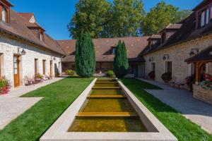 梧玖Hotel Le Clos De La Vouge的庭院中间带池塘的花园