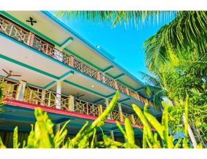 哈夫洛克岛The Ocean Blue Resort, Havelock Island的前院内带棕榈树阳台的建筑