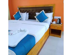 哈夫洛克岛The Ocean Blue Resort, Havelock Island的一间卧室配有一张带蓝白色枕头的大床