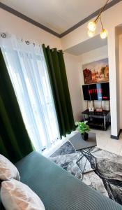 碧瑶A Perfect Stay to Escape the City的一间带绿色窗帘的卧室、一张床和电视