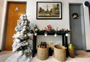 碧瑶A Perfect Stay to Escape the City的圣诞壁炉,配有圣诞树和篮子