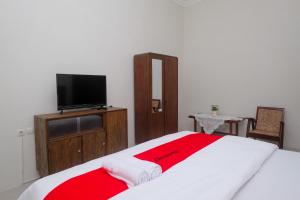 KlatenRedDoorz Syariah near Stasiun Klaten的一间卧室配有一张带红白毯子的床