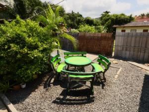 象岛Lemon Guesthouse的一个带绿色桌椅的庭院