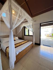 爱妮岛Ursula Beach Resort的一间卧室配有一张带蚊帐的床