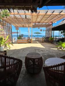 爱妮岛Ursula Beach Resort的一个带桌椅的庭院和大海