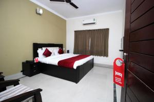 普里Hotel Sai Leela的一间卧室,配有一张床和一个红色标志