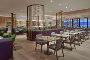 米西索加多伦多机场希尔顿酒店的一间带桌椅的餐厅和一间酒吧