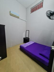 KeterehZara Homestay @ Kok Lanas的白色客房内的一间卧室配有一张紫色的床