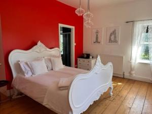 布拉克利Walltree House的卧室设有白色的床和红色的墙壁