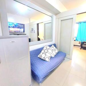 马尼拉Sea Residences by Jan & Val Alano的厨房配有蓝色沙发,设有冰箱