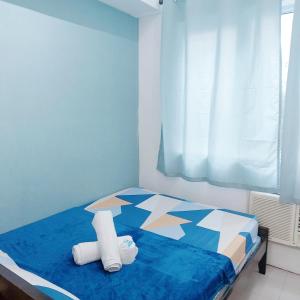 马尼拉Sea Residences by Jan & Val Alano的一间卧室配有蓝色的床和毛巾