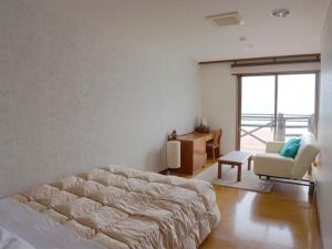 屋久岛海洋蓝屋久岛酒店的一间卧室配有一张床、一张桌子和一把椅子