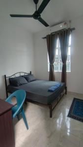 淡马鲁BAUNG GUEST HOUSE TEMERLOH的一间卧室配有一张床、一张蓝色的桌子和窗户。