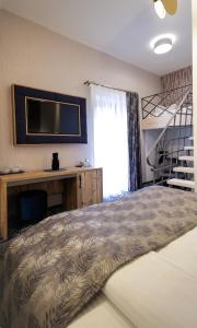 锡比乌ART Hotel的一间卧室配有一张床、一张书桌和一台电视