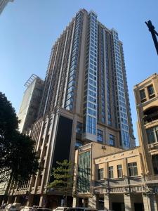 广州WAIFIDEN service Apartment Min Jian Fianance Branch的一座高大的建筑,前面有汽车停放