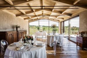 San NicolòCountry House Oliveto sul Lago的一间设有白色桌椅和窗户的用餐室