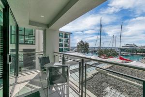 奥克兰Fabulous Corner Apartment w/ Dazzling Harbour View的阳台配有椅子,享有码头的景致