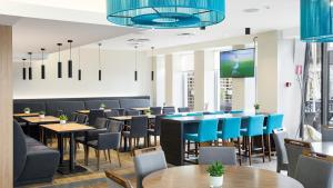 塔林Hestia Hotel Seaport Tallinn的一间配备有桌子和蓝色椅子的用餐室