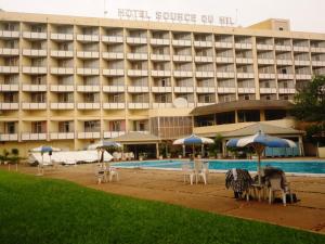 布琼布拉Hôtel Source Du Nil的一个带游泳池、椅子和遮阳伞的酒店