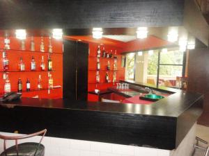 布琼布拉Hôtel Source Du Nil的厨房配有红色橱柜和黑色台面