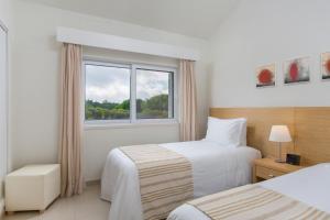 金塔湖Vilar do Golf的酒店客房设有两张床和窗户。