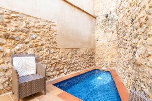 波连斯萨Casa Romana的一座带椅子的游泳池,毗邻石墙