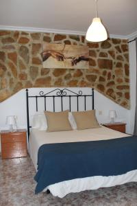 卡索拉Casa La Azotea de Cazorla的一间卧室设有一张大床和石墙
