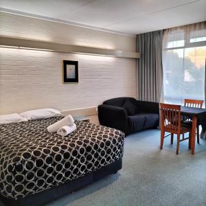 旺加拉塔旺加拉塔汽车旅馆 的酒店客房,配有床和沙发