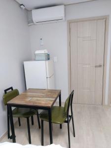 釜山Ara Guesthouse的厨房配有桌椅和冰箱。