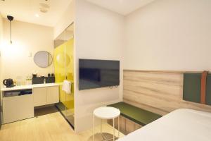淡水雀客快捷新北淡水的客房设有1张床、1台电视和1张桌子。