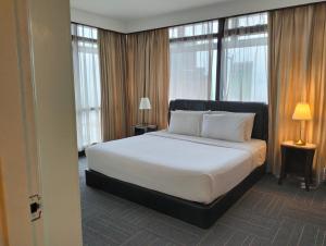吉隆坡Luxy Service Apartment at Times Square KL的卧室设有一张带窗户的白色大床