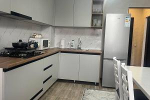 比什凯克Apartament Manasa的厨房配有白色橱柜和白色冰箱。
