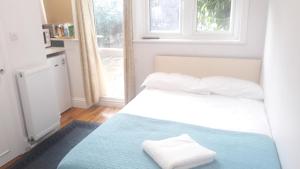 伦敦Luxury studio flat的一间卧室配有一张床,上面有两条毛巾