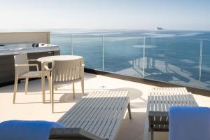 ŻurrieqDeep Blu Boutique Hotel的阳台配有桌椅,享有海景。