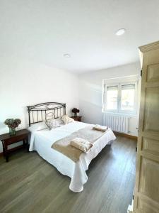 桑提亚纳德玛Maysa的白色的卧室设有床和窗户