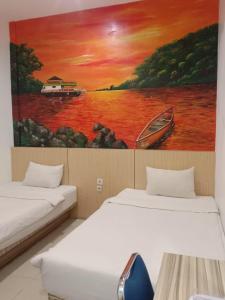 SintangLadja Hotel Sintang的墙上画画的房间里设有两张床