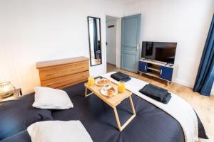 圣但尼Confort au Stade de France !的一间卧室配有一张大床和一张桌子