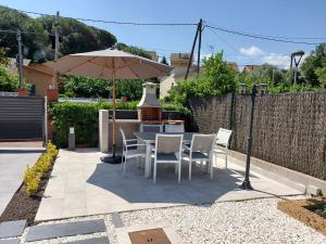 San Antonio de VilamajorCasa parque Natural Montseny con piscina, barbacoa y Chimenea的庭院配有桌椅和遮阳伞。