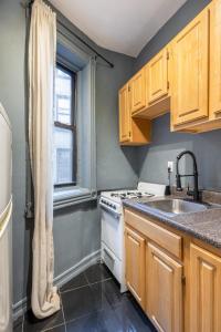 纽约Apartment 242: Upper West Side的厨房配有炉灶、水槽和窗户。