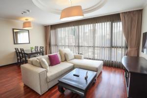 曼谷Bandara Silom Suites, Bangkok的客厅配有沙发和桌子