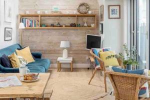 法尔茅斯Harbour Strand的客厅设有蓝色的沙发和木墙