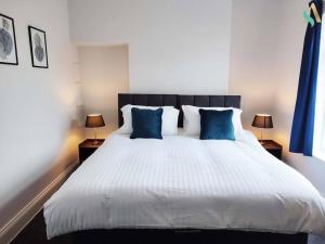 蒂斯河畔斯托克顿St Bernard House TSAC的卧室配有带蓝色枕头的大型白色床