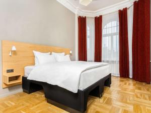 里加Tribe Riga City Center的一间卧室配有一张带红色窗帘的大床