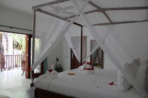 帕杰Kivuli Beach Resort Paje的一间卧室配有一张带天蓬的白色床