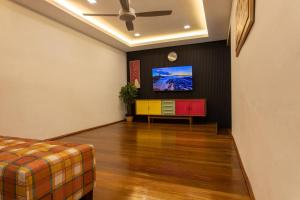 阿罗士打Rumah Satu by NK的客厅配有沙发和墙上的电视