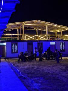 卡索尔Damnbro Cafe & Stay KASOL的一群人晚上坐在建筑物外面