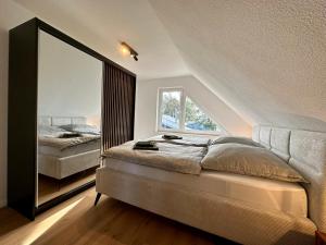 SüdbrookmerlandFerienhaus Franke am Großen Meer的一间卧室配有一张床和一面大镜子