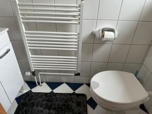 格雷沃斯米伦Ferienhaus - a90588的浴室铺有黑白地板,设有白色卫生间。
