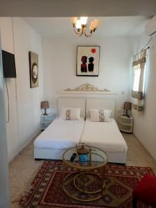 Sicca VeneriaCasa Zitouna - Guest House - Kef, Tunisia的一间卧室配有一张床和一张玻璃桌